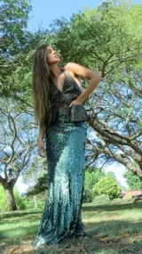 Pollera larga de corte godet, cubierta completamente de lentejuelas verde azulado, con flecos en el ruedo.