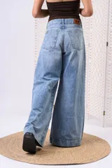 Pantalón wide leg de denim con lavado celeste vintage, tiro medio y dobladillo ancho marcado en las botamangas.