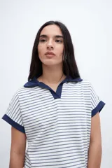 Remera con cuello tipo polo y escote en V, a rayas horizontales color beige y blanco, con cuello y mangas color beige liso.