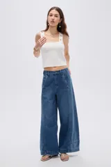 Pantalón jean azul de tiro alto, corte baggy y piernas anchas, con costuras decorativas frontales.
