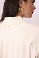 Camisa blanca de corte oversize, con cuello clásico y mangas largas con puños abotonados.