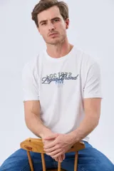 Remera blanca de manga corta y cuello redondo, con diseño frontal que combina estampa y bordado con la inscripción "Legacy Brand LGC 1972".