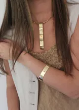 Collar rígido dorado con dije rectangular con perforaciones.