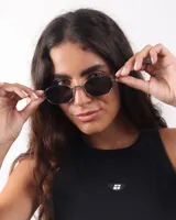 Lentes de sol con marco plateado y lentes grises.