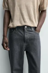 Jeans de corte straight fit, color gris oscuro, confeccionados en denim de algodón rígido, con diseño de cinco bolsillos y cierre frontal con cremallera y botón.