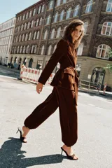 Pantalón de tiro medio confeccionado en terciopelo color marrón, con diseño bombacho, bolsillos delanteros y bajos con puño elástico. Cuenta con cierre lateral oculto.