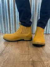 Botín marrón de cuero con elásticos laterales, suela de goma color caramelo y puntera reforzada.