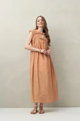 Vestido largo color naranja con estampado abstracto, escote con lazo ajustable y sin mangas.