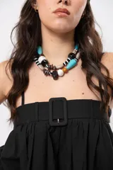 Top negro de diseño versátil con tirantes finos, silueta abombada, elástico en la espalda y hebilla forrada en el frente.
