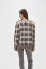 Cardigan de punto con diseño de cuadros, cuello en V y cierre frontal con botones. Presenta un corte holgado y mangas largas.