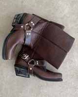 Bota de cuero marrón con caña alta y estribo desmontable.