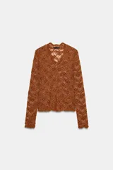 Top de manga larga color marrón óxido, confeccionado en tejido de encaje floral. Presenta escote en V con cierre frontal de botones pequeños.