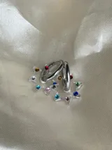 Aros tipo argolla dorada con dije colgante en forma de estrella de acrílico color rosa.