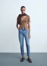 Jeans de tiro alto con corte mom-fit, diseño crop y cinco bolsillos. Presenta cierre frontal con cremallera y botón, y trabillas para cinturón.