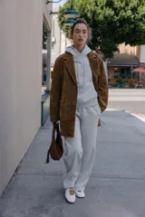 Chaqueta larga de piel color marrón, con cuello solapa, manga larga, bolsillos delanteros de plastrón y cierre frontal con botones.