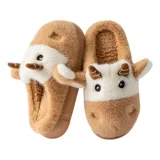 Pantuflas de peluche con diseño de vaca, confeccionadas en piel sintética suave. Cuentan con suela de goma antideslizante y diseño abierto en el talón.
