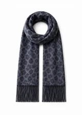 Bufanda de textura suave con estampado animal print en tonos grises, terminada con flecos en los extremos.