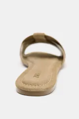 Sandalia plana color beige con tiras cruzadas en la parte delantera.