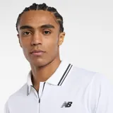 Remera polo blanca de hombre, marca New Balance, modelo Tournament. Confeccionada en tejido de poliéster reciclado y elastano con tecnología NB DRY de secado rápido. Presenta cuello tipo polo con cremallera invisible y logo bordado en el pecho.