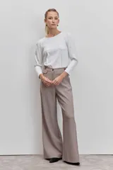 Pantalon de vestir de corte sastrero y pierna ancha, con estampado de cuadros tipo príncipe de gales en tonos tierra. Presenta cintura alta con trabillas, cierre frontal con botones y bolsillos laterales con detalle de ribete.