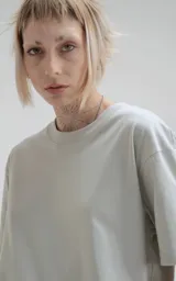 Remera de manga corta y cuello redondo, color gris claro, con calce regular y un recorte sutil en la espalda. Confeccionada en algodón premium suave.