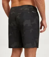 Bermuda deportiva de poliéster con estampado camuflado en tonos grises y blancos, cintura elástica con cordón ajustable y bolsillos laterales con cierre.