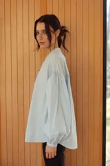 Camisa celeste con cuello mao y mangas abullonadas.