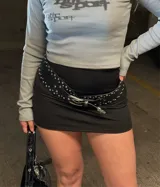 Minifalda negra de tiro alto y corte ajustado, confeccionada en tela elástica.