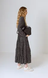 Vestido midi negro con corte en la cintura y falda amplia con volados.