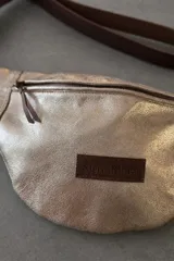 Riñonera con estampado animal, con detalles en cuero color chocolate y correa regulable.