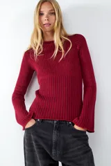Sweater de punto color rojo con cuello redondo y mangas largas levemente acampanadas. Presenta diseño de rayas en contraste y ruedo recto.