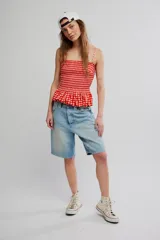 Musculosa de cuadros vichy rojos y blancos, con cuerpo fruncido elastizado, escote recto, tirantes finos y diseño peplum con vuelo en el ruedo.