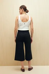 Pantalón capri negro acampanado de algodón con inspiración cargo, corte amplio y bolsillos laterales.