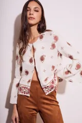 Blusa blanca con bordado de cachemir en negro, corte oversize y mangas acampanadas.