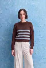 Sweater marrón de tejido liviano con calce relajado, escote redondo y mangas largas. Cuenta con diseño de rayas horizontales celestes en la parte frontal y terminaciones acanaladas.
