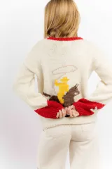 Buzo de lana merino color crema con diseño tejido de un cowboy montando un caballo en la espalda. Presenta detalles en color rojo en el cuello y en los puños de las mangas.