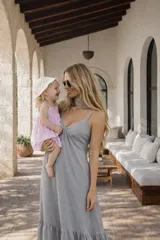 Vestido largo negro de algodón con breteles finos, escote en V y choker al cuello. Falda amplia con volado en el ruedo.