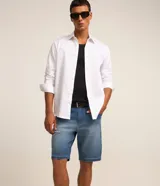 Bermuda slim de jean color azul gastado, con bolsillos laterales y traseros, cierre frontal con botón y bragueta, y diseño de dobladillos.