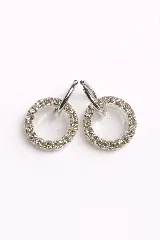 Par de aros colgantes con argolla de acero quirúrgico y dije circular de resina transparente con borde de strass.