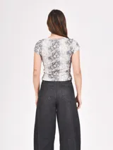 Remera marrón con estampado animal print, cuello redondo y mangas cortas.