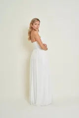 Vestido de novia blanco de gasa con corte imperio, escote corazón y detalles bordados en piedras. Presenta un corsé drapeado y falda larga con caída fluida.