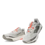 Championes de running New Balance modelo Nitrel, color gris con detalles en naranja y suela con tecnología AT Tread. Presenta diseño de malla transpirable y refuerzo Toe Protect en la puntera.