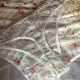 Bombacha colaless confeccionada en microtul translúcido con estampados variados, terminaciones con borde picot y un pequeño moño decorativo en la cintura.