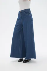 Pantalon de jean azul de corte ancho y tiro alto, con ruedo deshilachado.