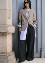 Pantalón vaquero de corte wide leg y tiro medio, confeccionado en tejido 100% algodón con diseño largo y lavado rinse wash. Cuenta con trabillas, detalle de pinzas, dos bolsillos laterales y cierre oculto de ganchos y cremallera.