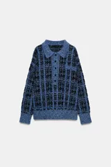 Jersey de punto con textura estructurada en tonos azules y negros, cuello polo con solapa, manga larga y cierre frontal parcial con botones.