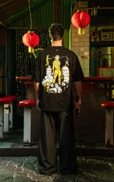 Remera negra de algodón con corte holgado y estampado frontal de un demonio con cuernos en color amarillo.