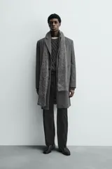 Abrigo regular fit de color gris oscuro, confeccionado en tejido con mezcla de lana de origen italiano. Cuenta con cuello con solapas de muesca, manga larga, bolsillos de vivo en la cadera, bolsillo interior, abertura en el centro de la espalda y cierre frontal de botonadura.