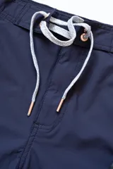 Short de baño azul marino con tira lateral blanca estilo tuxedo, cintura elástica con cordón regulable, dos bolsillos laterales y uno trasero con cierre.