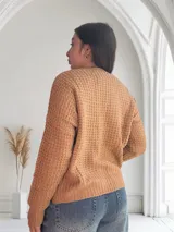 Saco de lana color camel con textura de punto, escote en V y cierre con botones marrones.